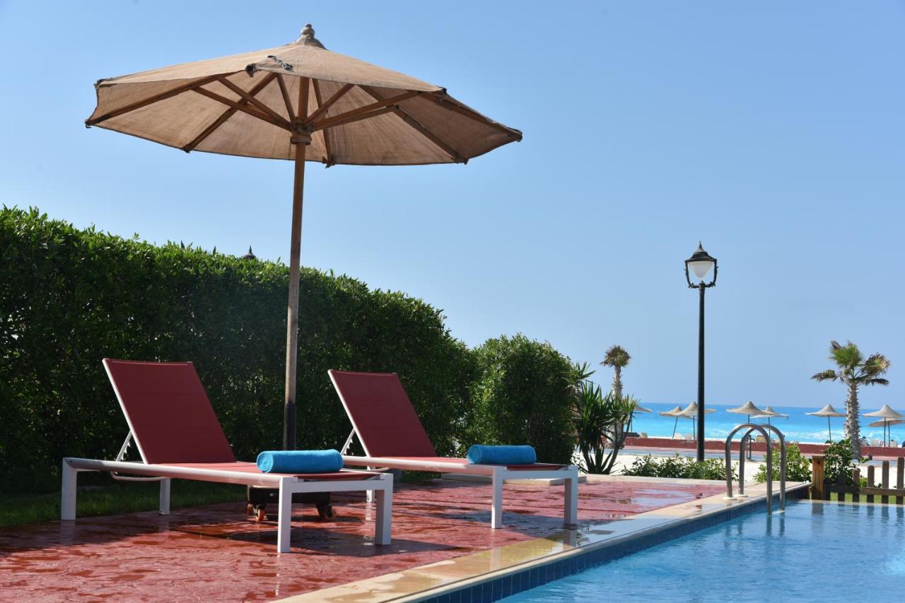 Tolip North Coast Hotel El Alamein Exterior foto A poolside umbrella